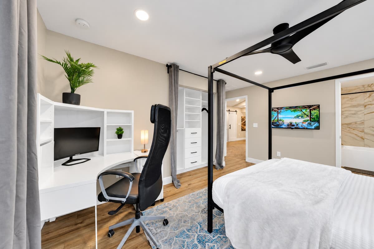 Sleep, work and unpack without leaving the room. Canopy king, built-in desk with a proper chair and a smart TV, in a suite designed for guests who stay a week or longer.
