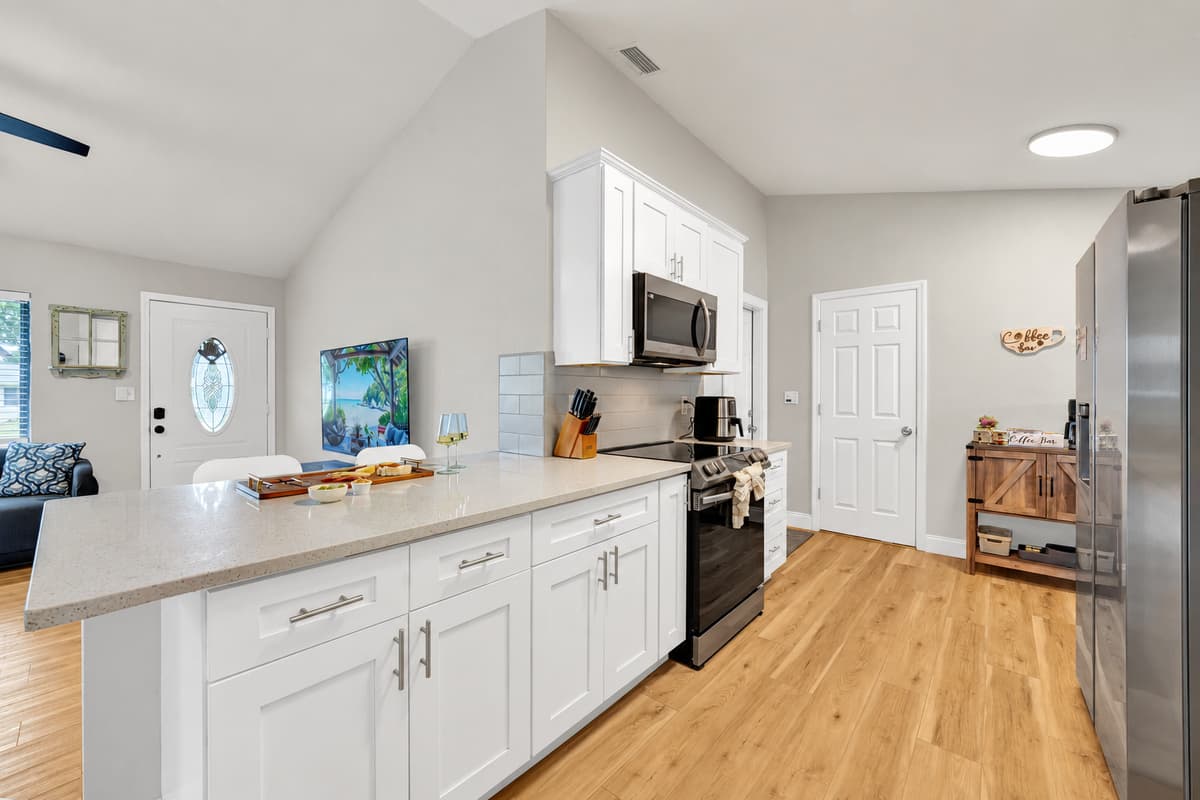 The peninsula does double duty: prep space on one side, extra seating on the other. Six at the dining table plus stools here means the whole group eats in one place, which almost never happens on a trip.