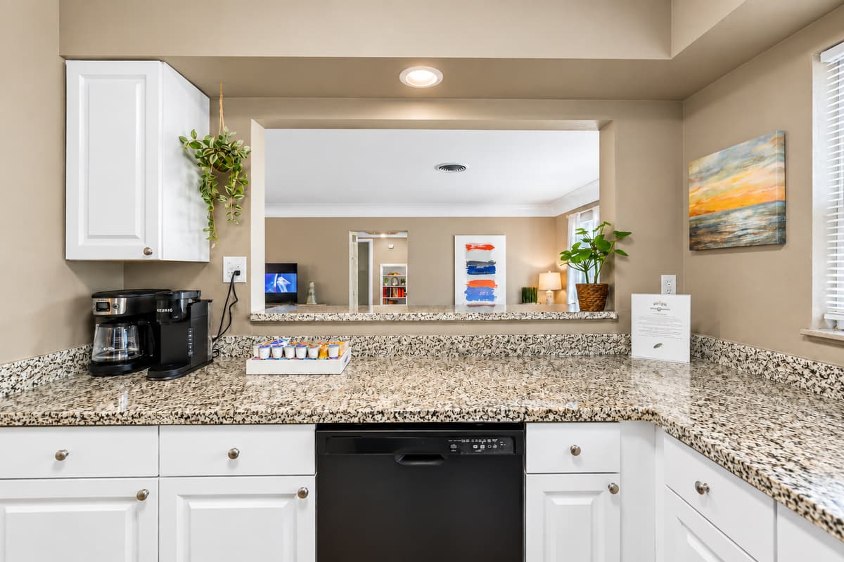 Bright and functional kitchen with granite countertops, coffee station, and open-concept design.