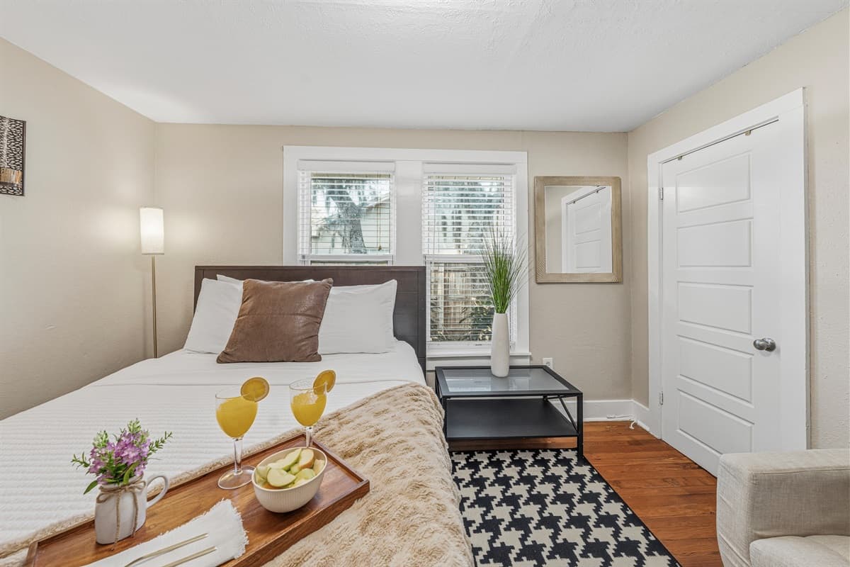 Cozy second bedroom with seating nook and warm, inviting touches.