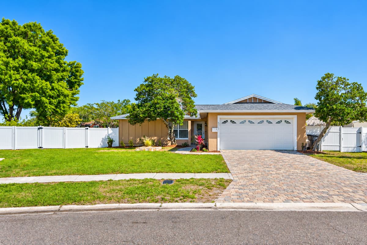 Beautiful front view of the house that has a wide driveway and a garage. Who doesn't love a view of green grass and beautiful trees around the house? If you like what you see, send us a message as soon as possible!