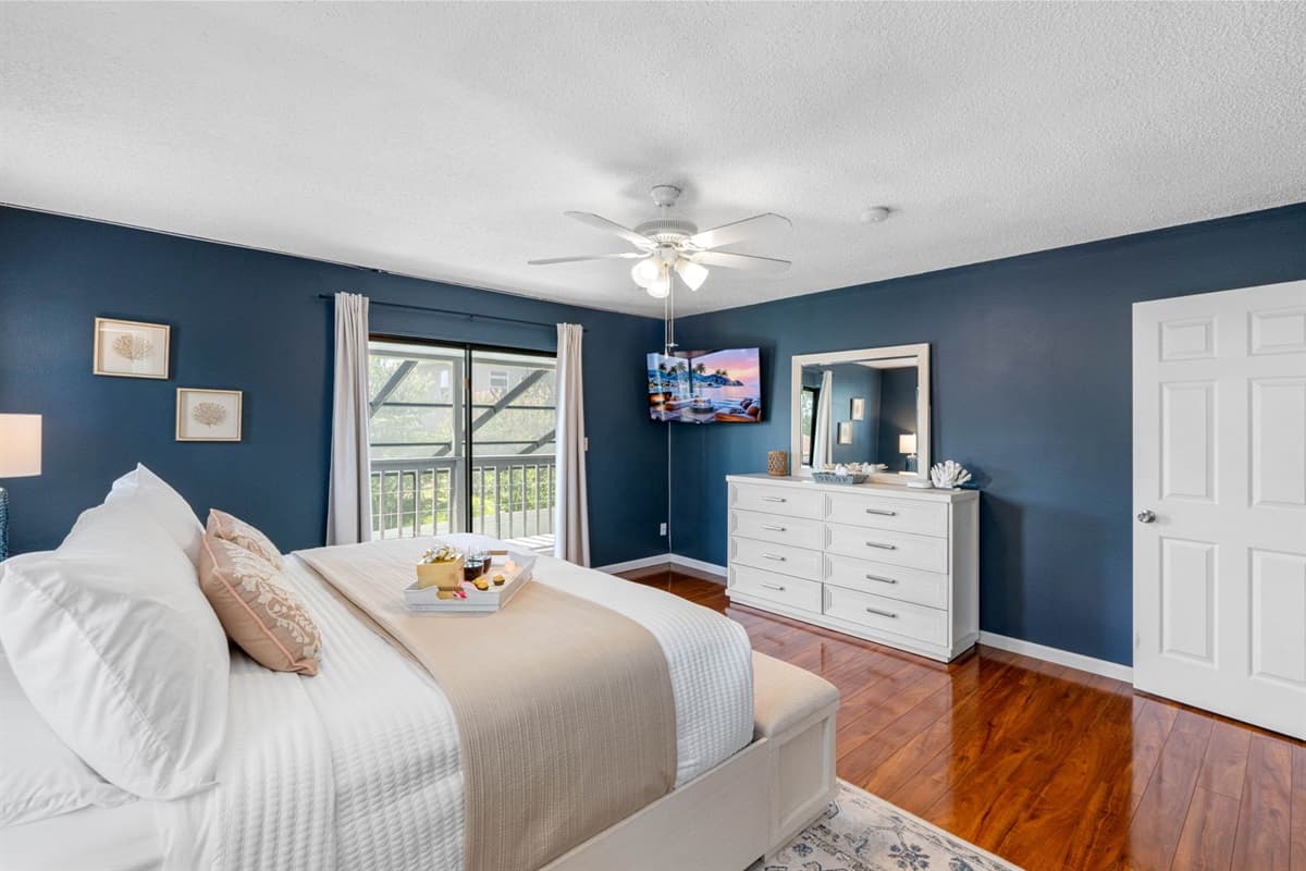 Unwind in this elegant bedroom where deep blue walls and soft lighting create a cozy, tranquil environment perfect for recharging.