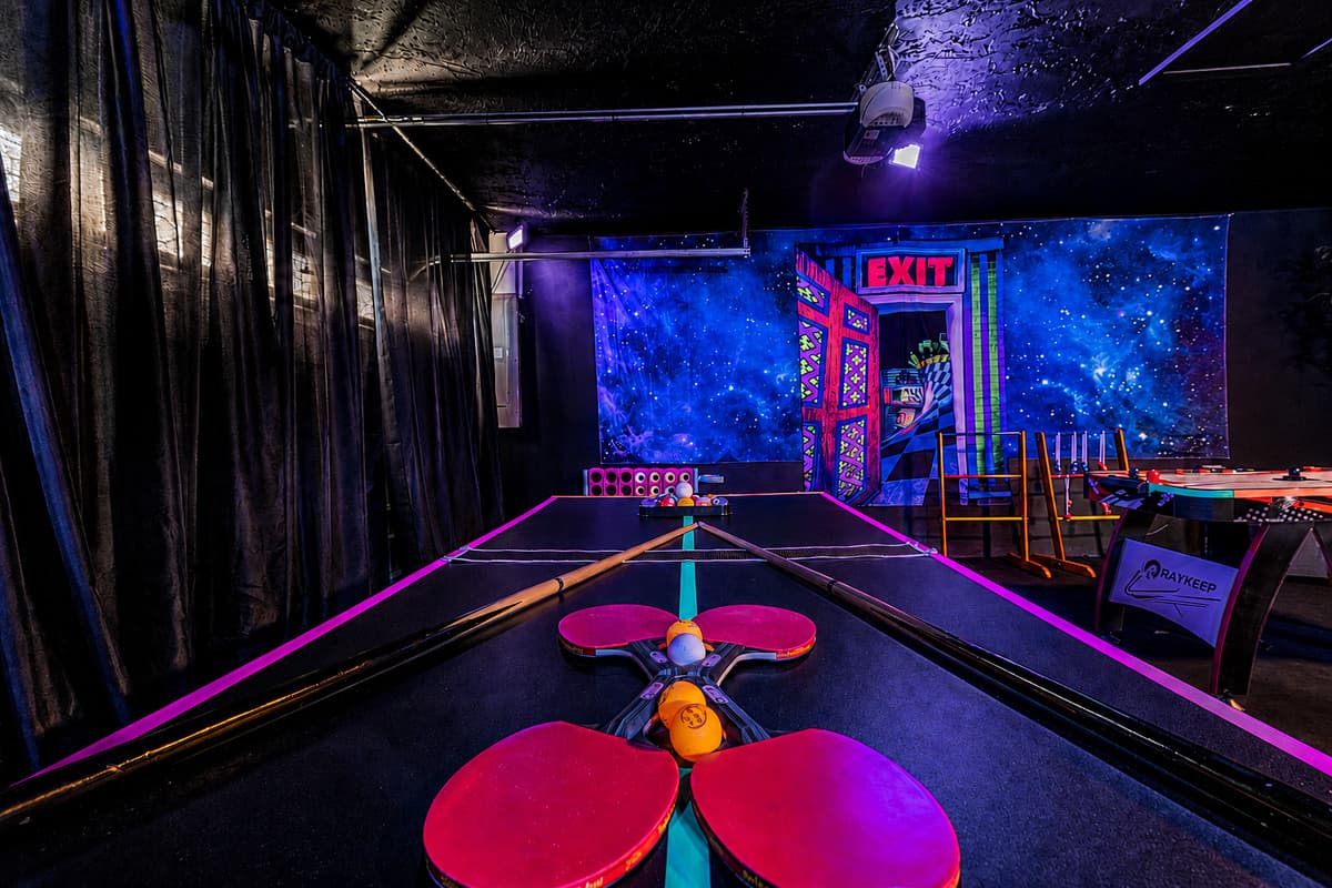 Ping pong under blacklight, galaxy walls all around. Nobody's played a game like this at a rental before.