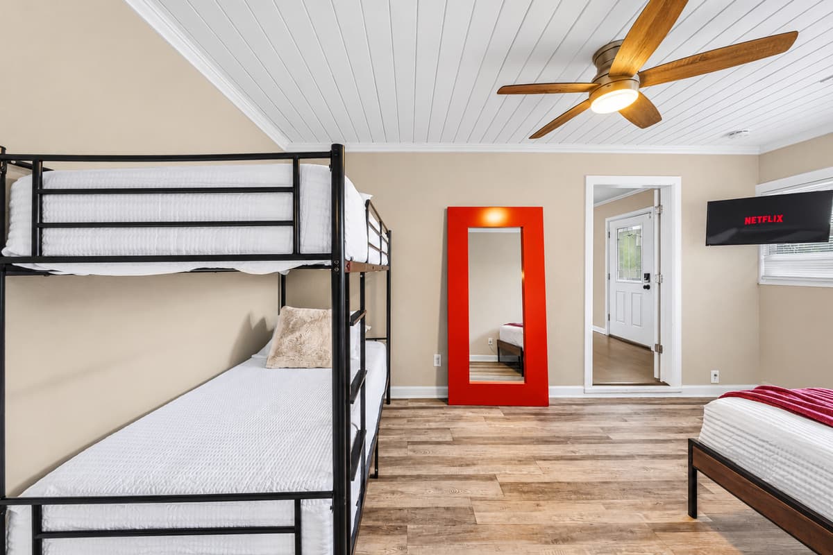 Large bunk room with ample sleeping space, TV, and fun setup for group accommodations.