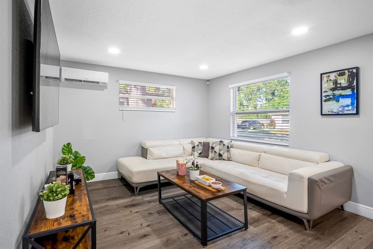 This bright and modern living room features a plush sectional sofa, smart TV, and plenty of natural light — perfect for movie nights or lazy afternoons.