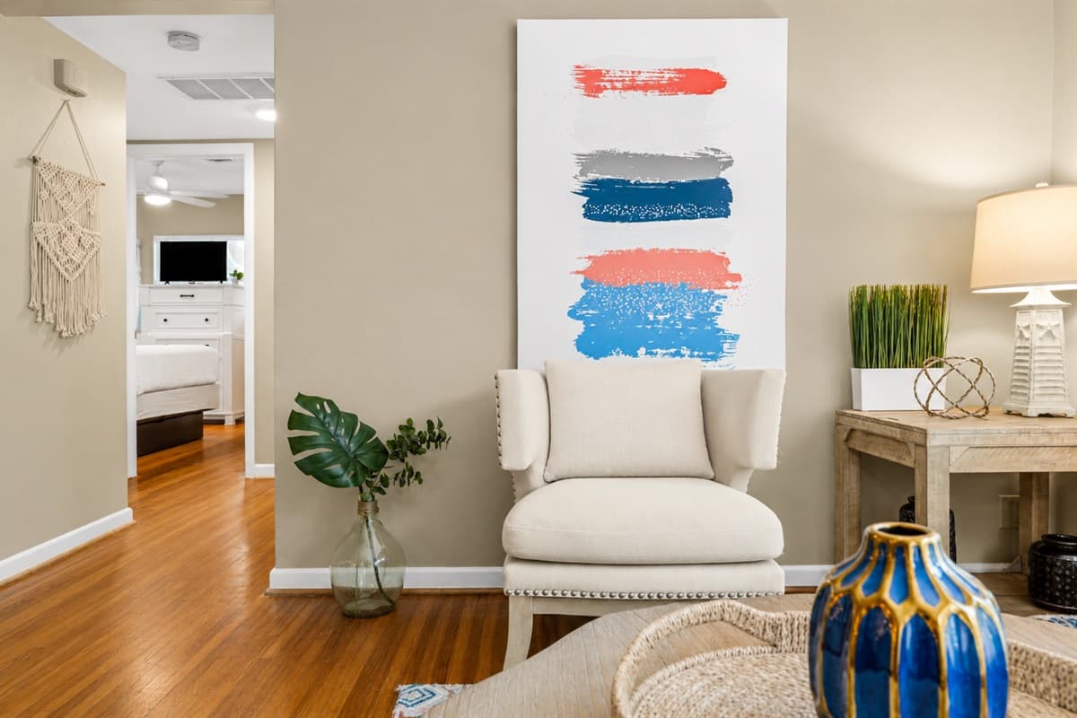 Stylish sitting nook with accent chair, modern artwork, and elegant decorative touches.