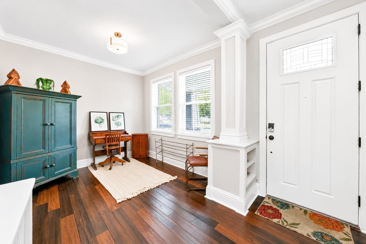 Step into a bright and inviting entry featuring a dedicated workspace, stylish décor, and beautiful hardwood floors.