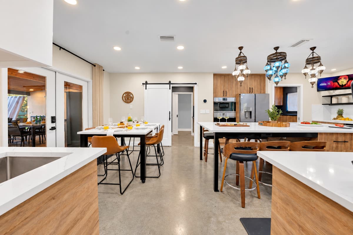 Kitchen, dining and lounge, all one room. The cook stays in the conversation, the table seats the group, and the whole house moves through here without anyone getting in the way.