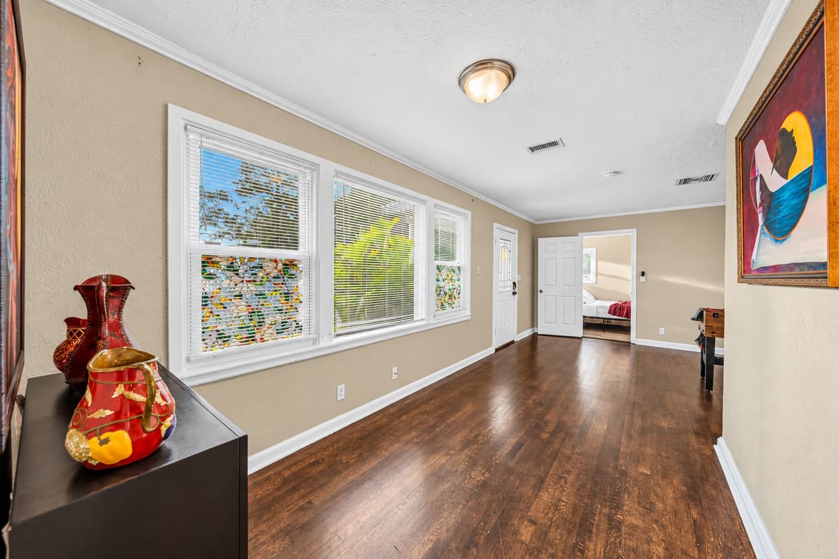 Bright hallway with large windows bringing in natural light and connecting living spaces.