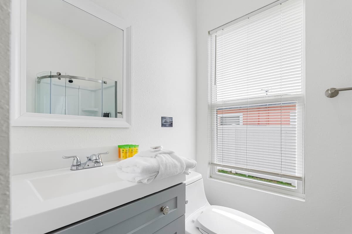 The ensuite bathroom attached to Bedroom 5 is thoughtfully designed with a compact glass shower, modern vanity, and crisp finishes that feel both practical and inviting.