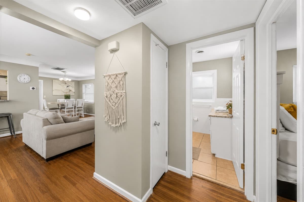 Open hallway and living space with warm wood flooring and easy access to the main common areas.