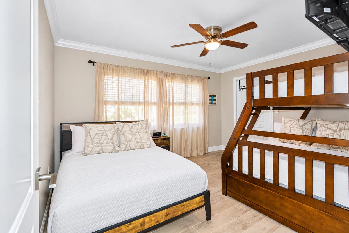 This spacious room features a cozy double bed, ideal for a restful night's sleep, along with a bunk bed and a trundle, providing additional sleeping arrangements that are perfect for kids or extra guests.