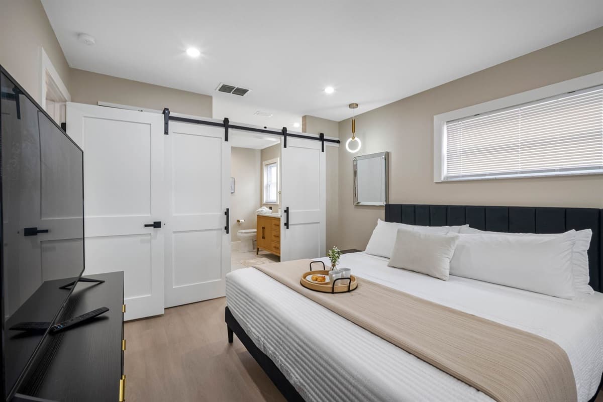This primary suite features a king bed, twin-over-twin bunk, smart TV, and a private ensuite bathroom for ultimate comfort.