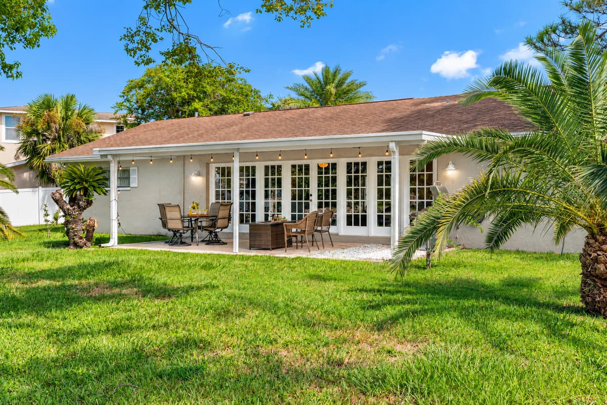 This covered patio offers a quiet retreat, complete with a fire pit and a charming view of the canal, surrounded by lush greenery.