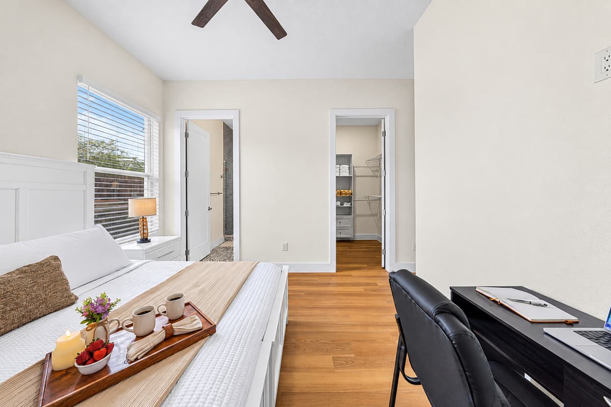 Bedroom with dual workspace setup and easy access to adjacent rooms.
