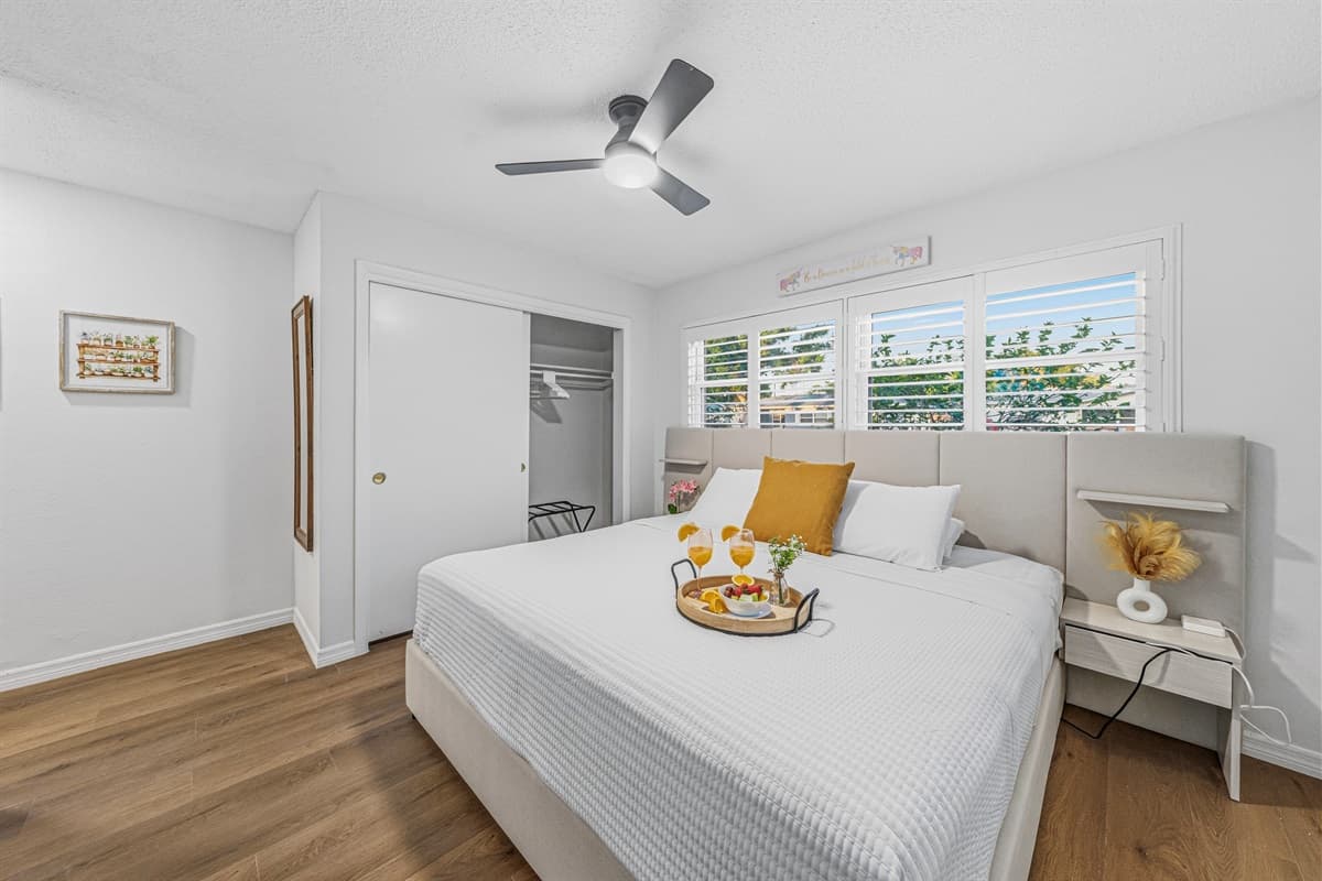 Bright and inviting king bedroom with clean design, natural light, and a relaxing atmosphere 
Tray and food setup shown are for staging purposes only and are not included.