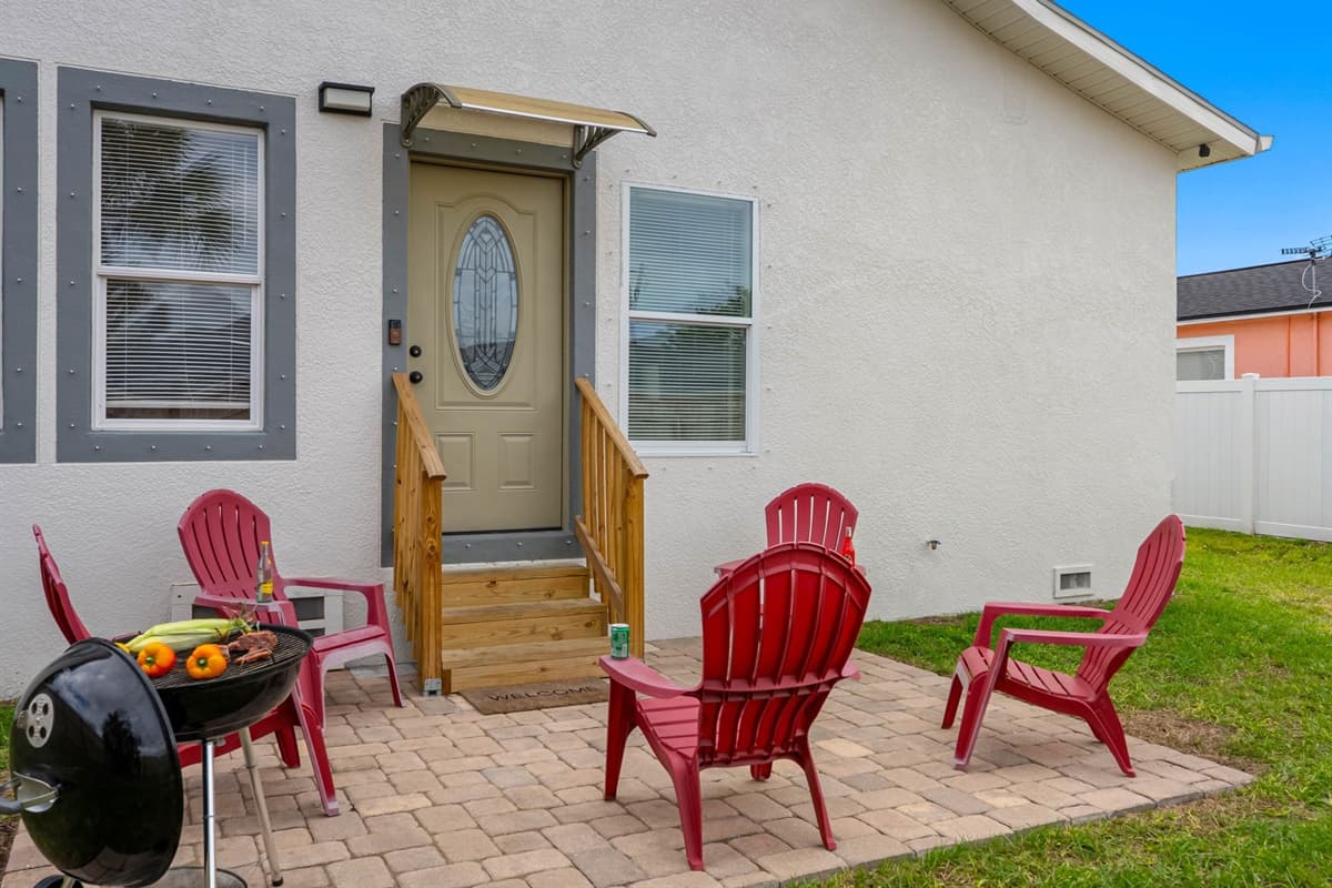 This inviting backyard setup offers ample seating around a charming outdoor space, ideal for grilling, sharing drinks, and spending quality time with family and friends.