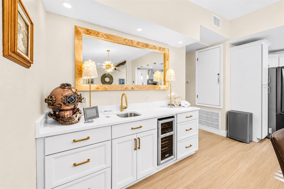 Stylish coffee and beverage station featuring modern cabinetry, mini fridge, and elegant accent lighting.