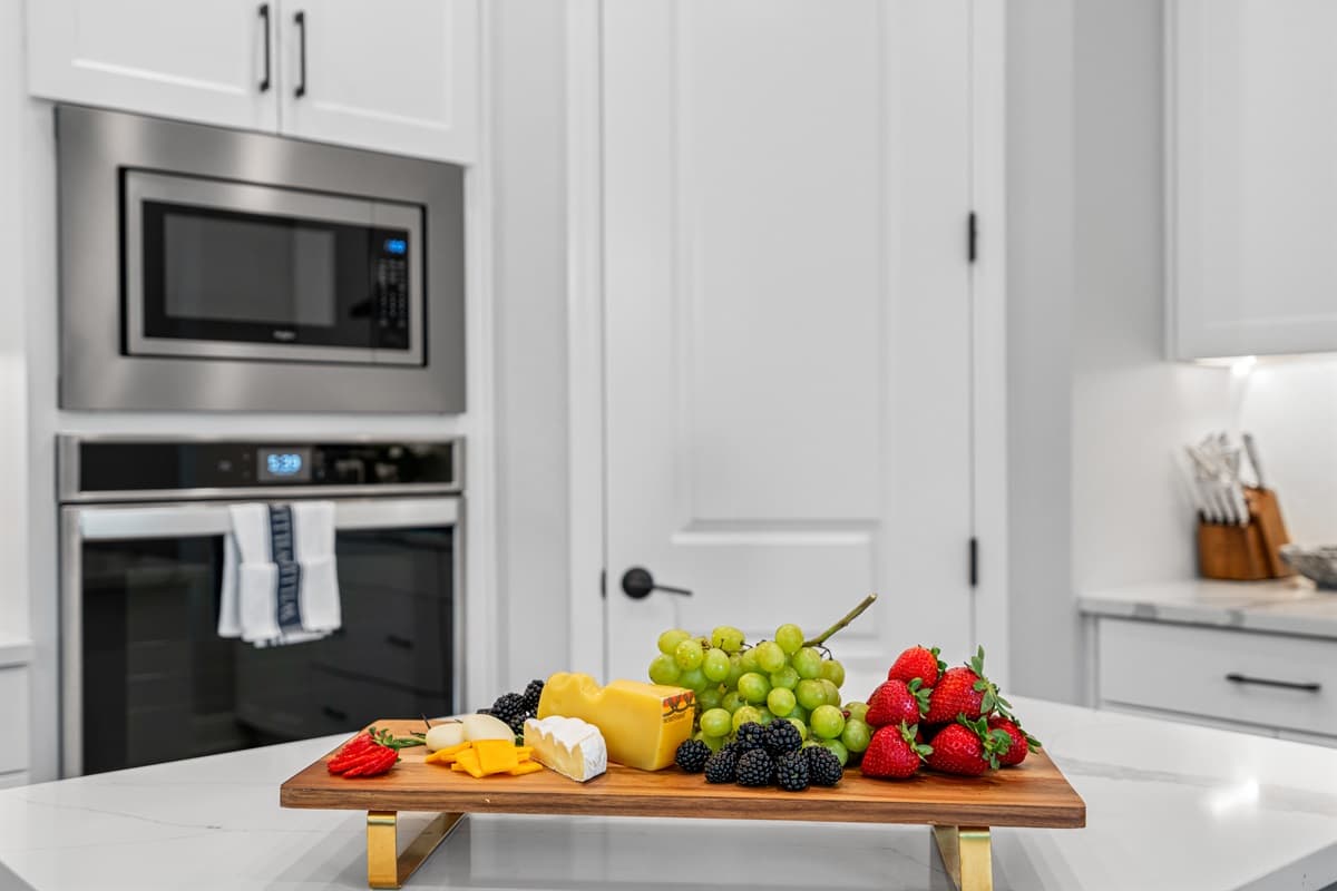 The stainless steel finish of the appliances contrasts beautifully with the white cabinetry, adding a touch of sophistication to the space.