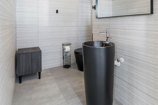 This well-appointed area serves as a convenient retreat for quick refreshers and essential personal care, making it an invaluable addition to the villa.