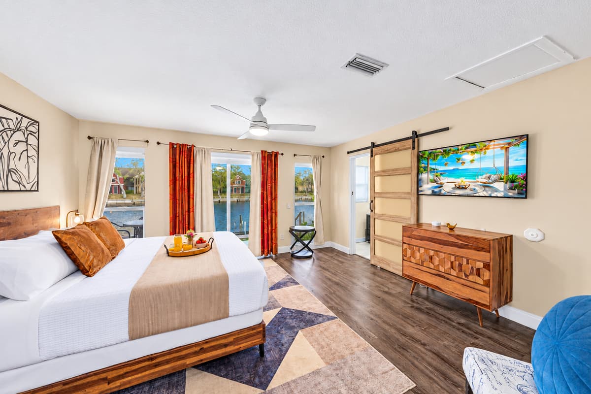 Stylish primary bedroom offering plenty of space, natural light, and tranquil water views.