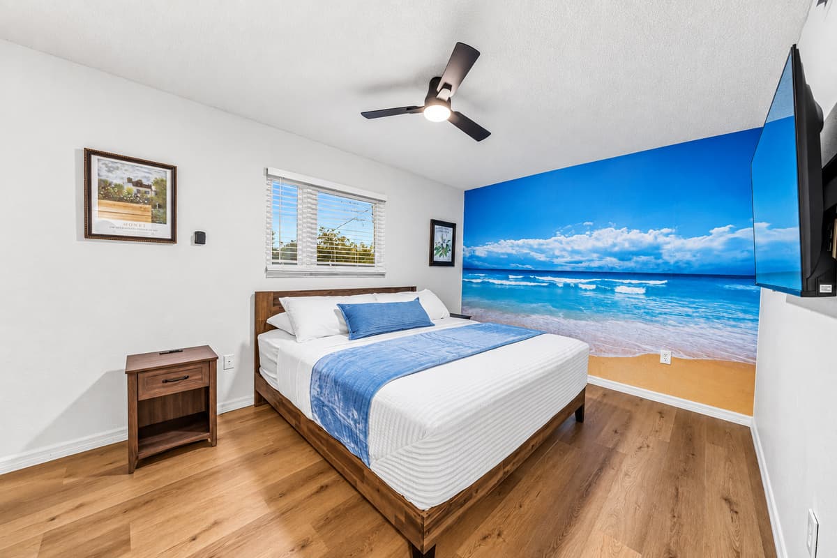 Unique bedroom with a stunning beach-themed accent wall, creating a tranquil coastal vibe 