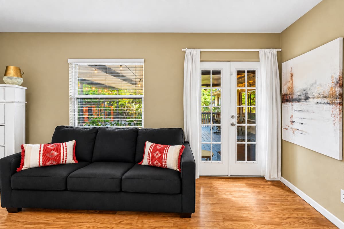 Comfortable bedroom lounge area with a sleeper sofa and direct access to the patio through French doors.