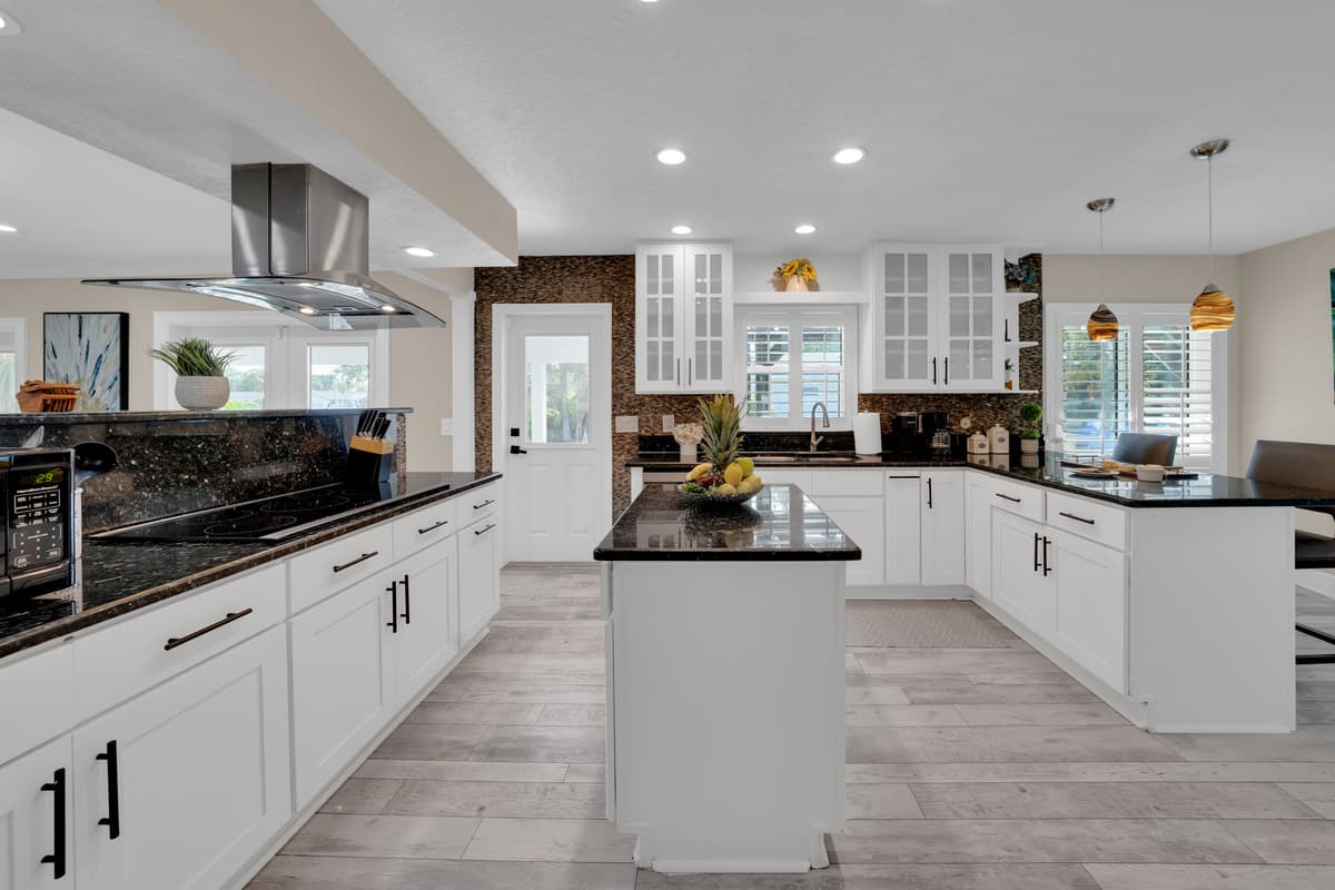 Crisp white cabinetry and dark granite counters give this spacious kitchen a fresh, high-end feel for group cooking