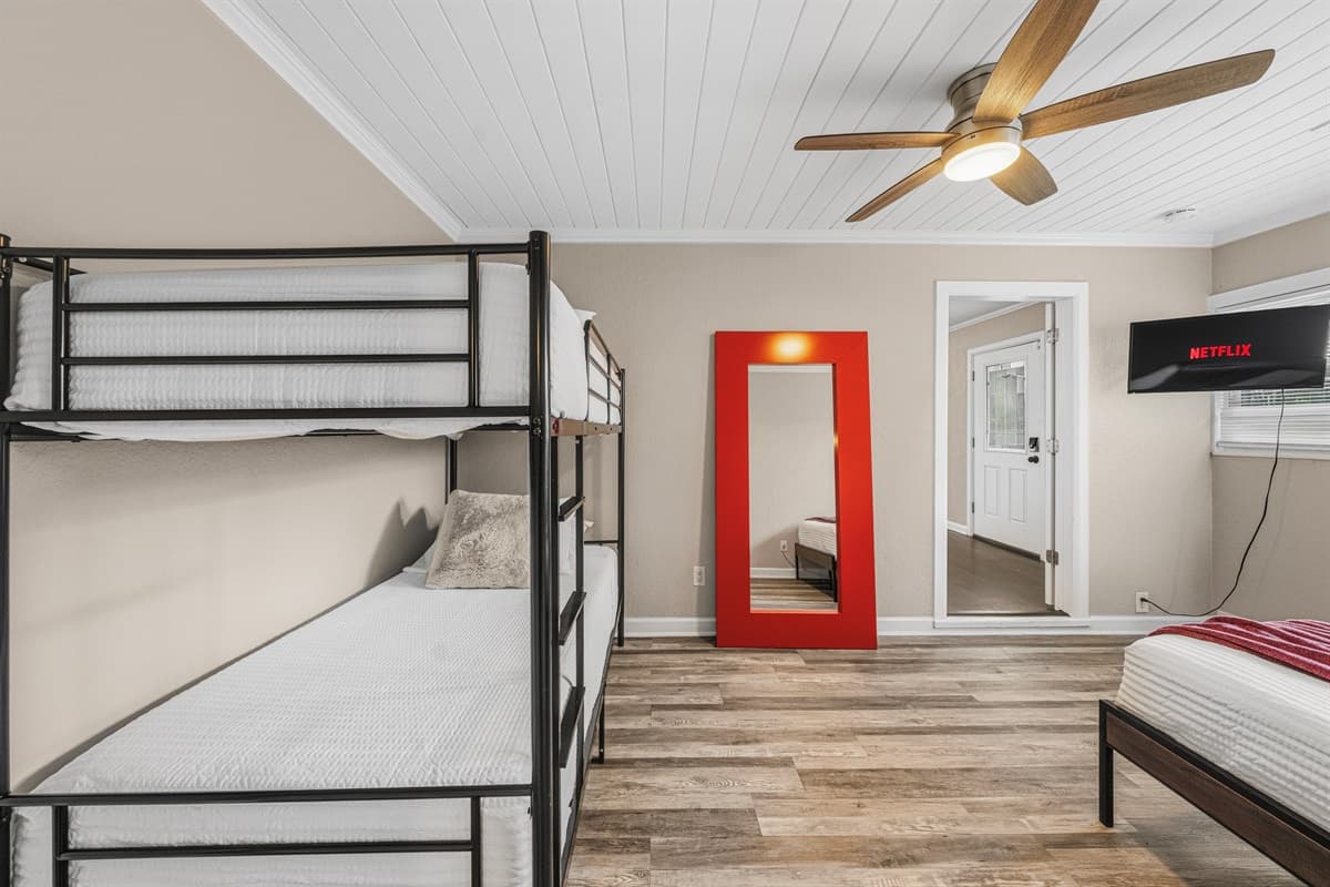 Large bunk room with ample sleeping space, TV, and fun setup for group accommodations.