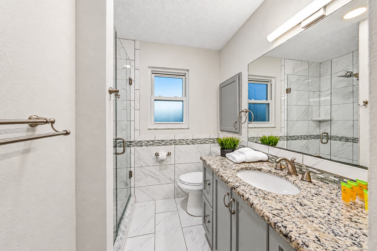 Updated bathroom with granite countertop, walk-in shower, and bright, clean finishes 