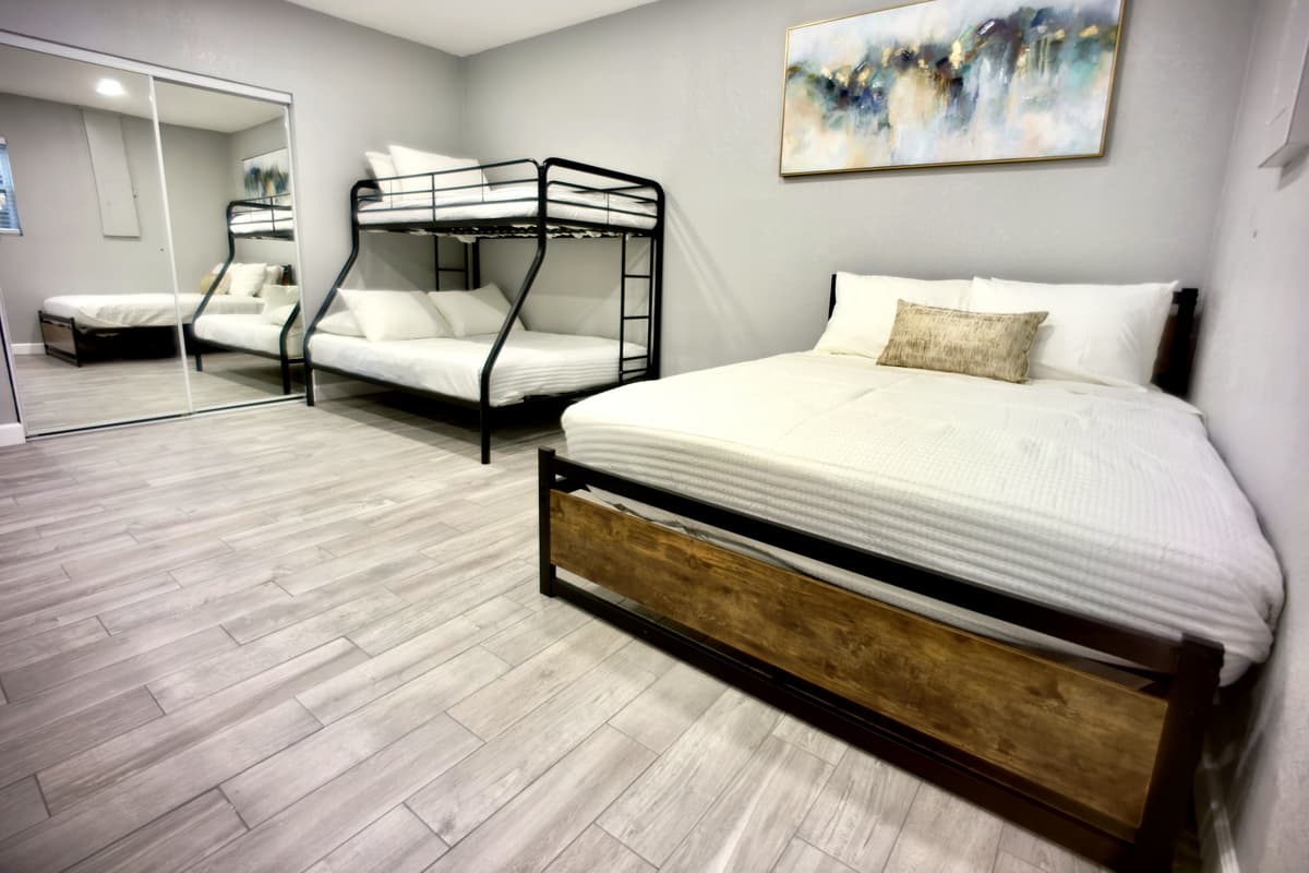 A spacious and inviting retreat with a queen-size bed, and a bunk bed, perfect for relaxation and restful nights.