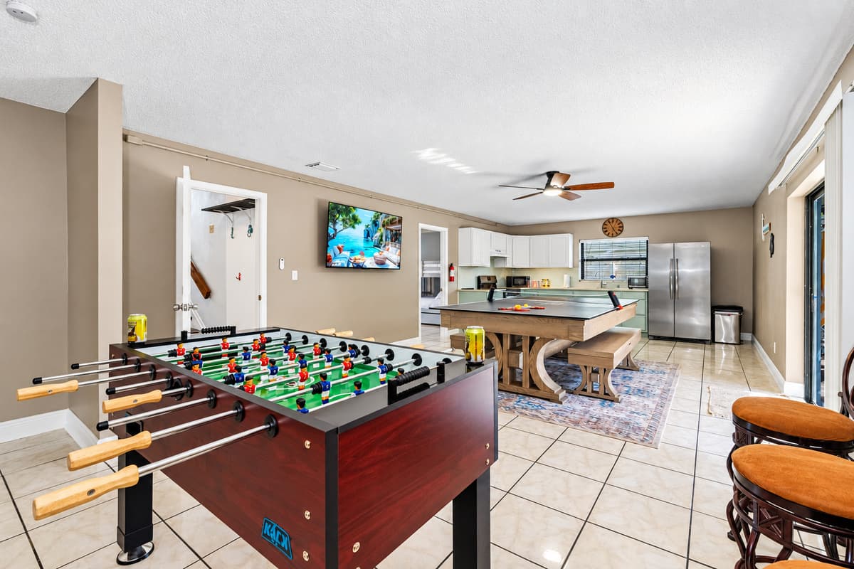 This open-concept area is perfect for family fun, with a full kitchen, foosball, and a convertible ping pong/dining table—plus sliding doors that lead right to the backyard.