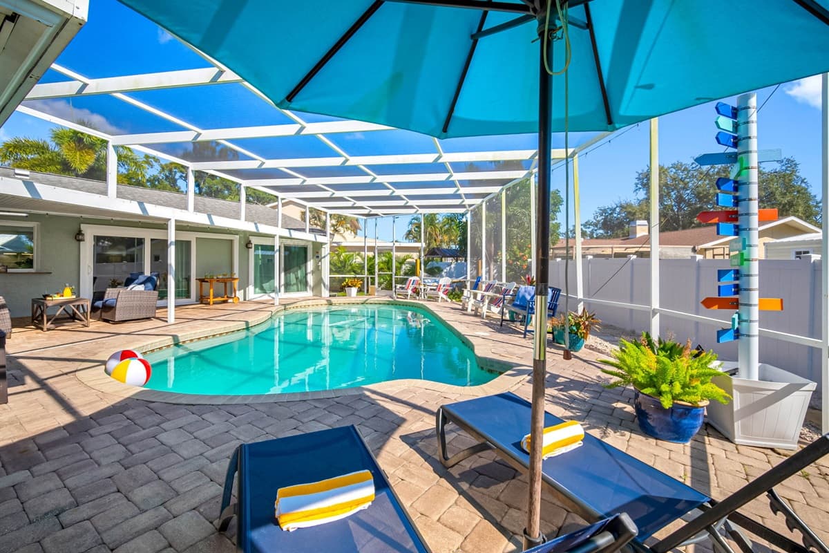 This screened-in pool deck brings resort vibes home, complete with lounge chairs, a shaded umbrella area, and plenty of space to enjoy Florida’s endless summer.