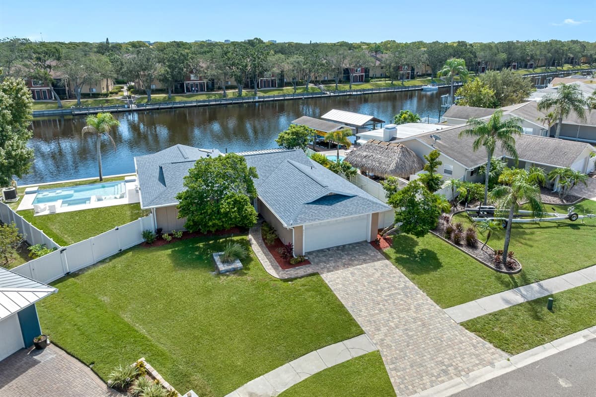 Aerial side view of our wonderful property what showcases our stunning heated pool, and beautiful driveway and our gorgeous fenced backyard. If you are interested in our property, send us an inquiry now!
