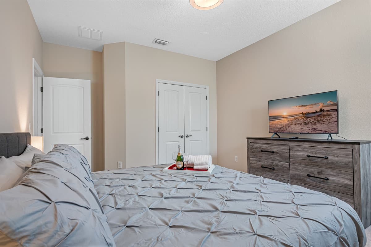 This immaculate bedroom has double-door closets, a wonderful and comfortable bed, a smart TV, and has built-in custom shelving and drawer storage units.