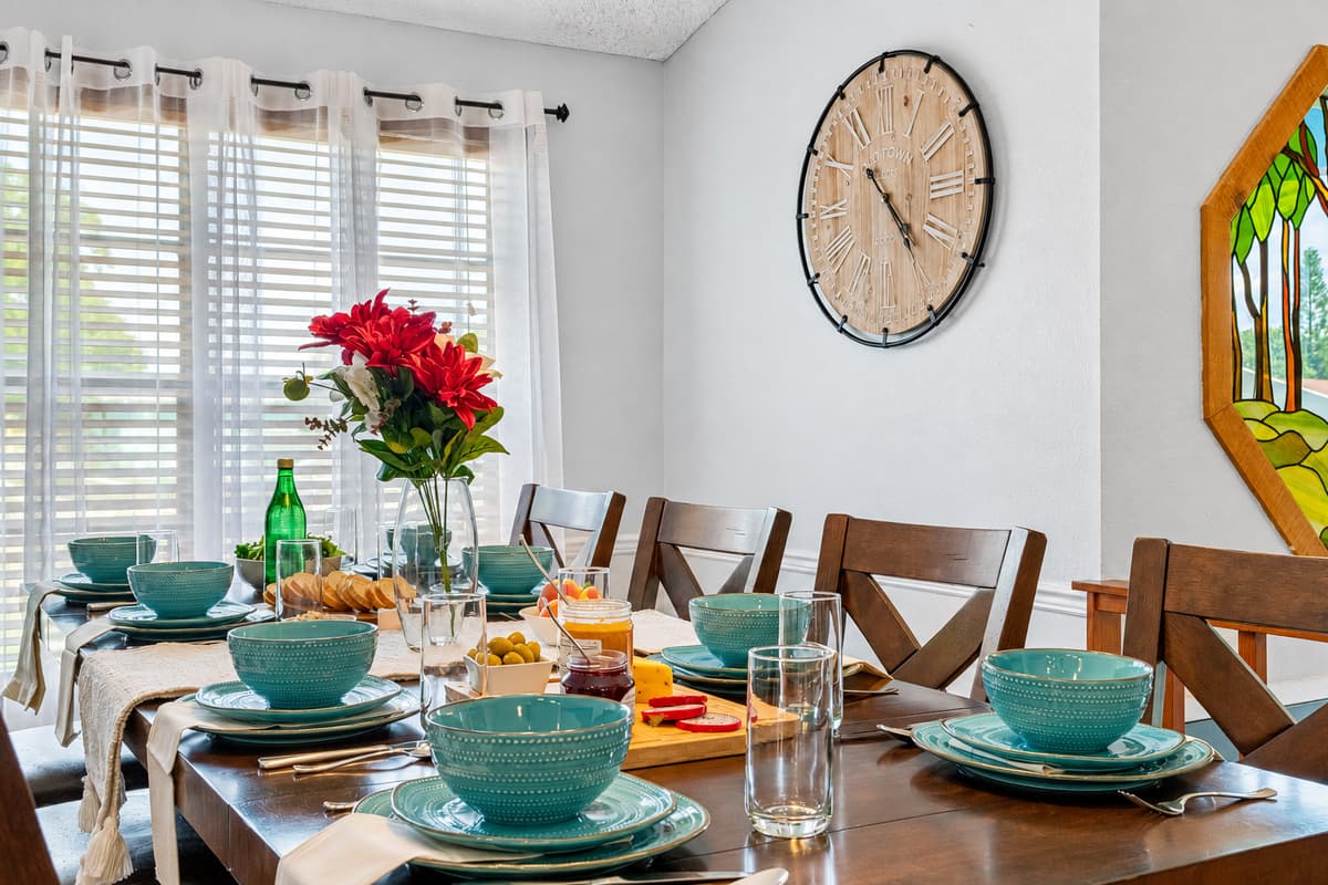 Enjoy comfort and style with this large, wood-finished dining table featuring cushioned chairs and beautiful natural lighting.