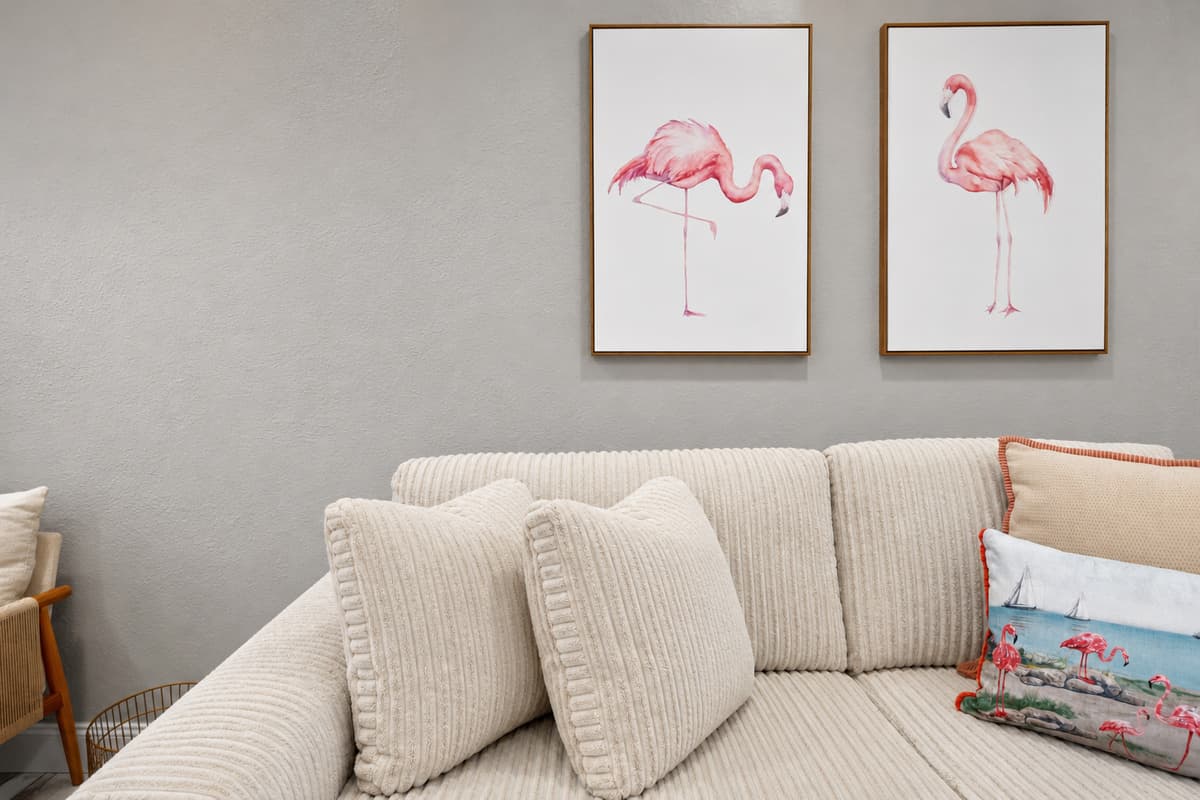 Decorative flamingo wall art above the sofa, reinforcing the home's tropical theme.