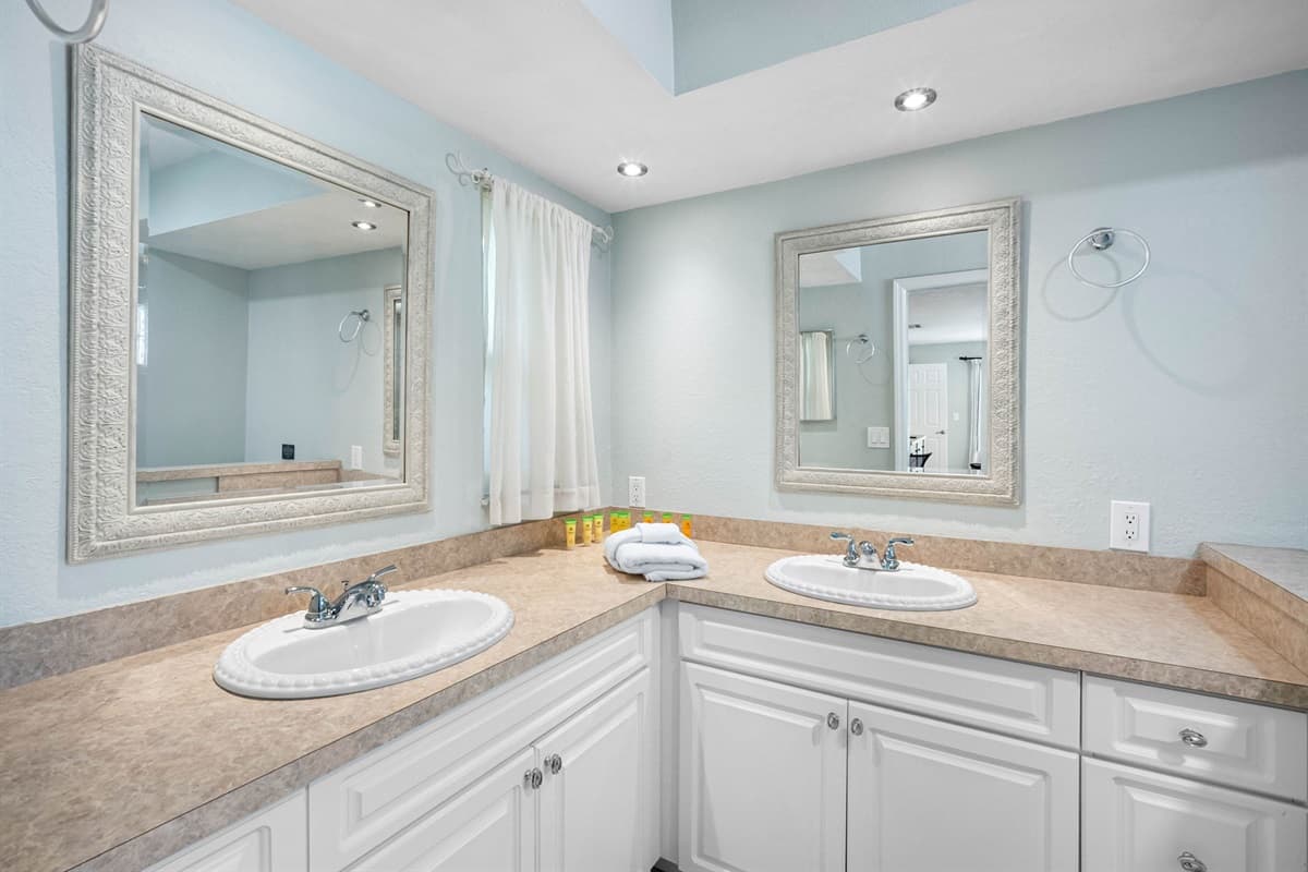 Featuring dual sinks, a glass-enclosed shower, and soft lighting for a relaxing start or end to your day.