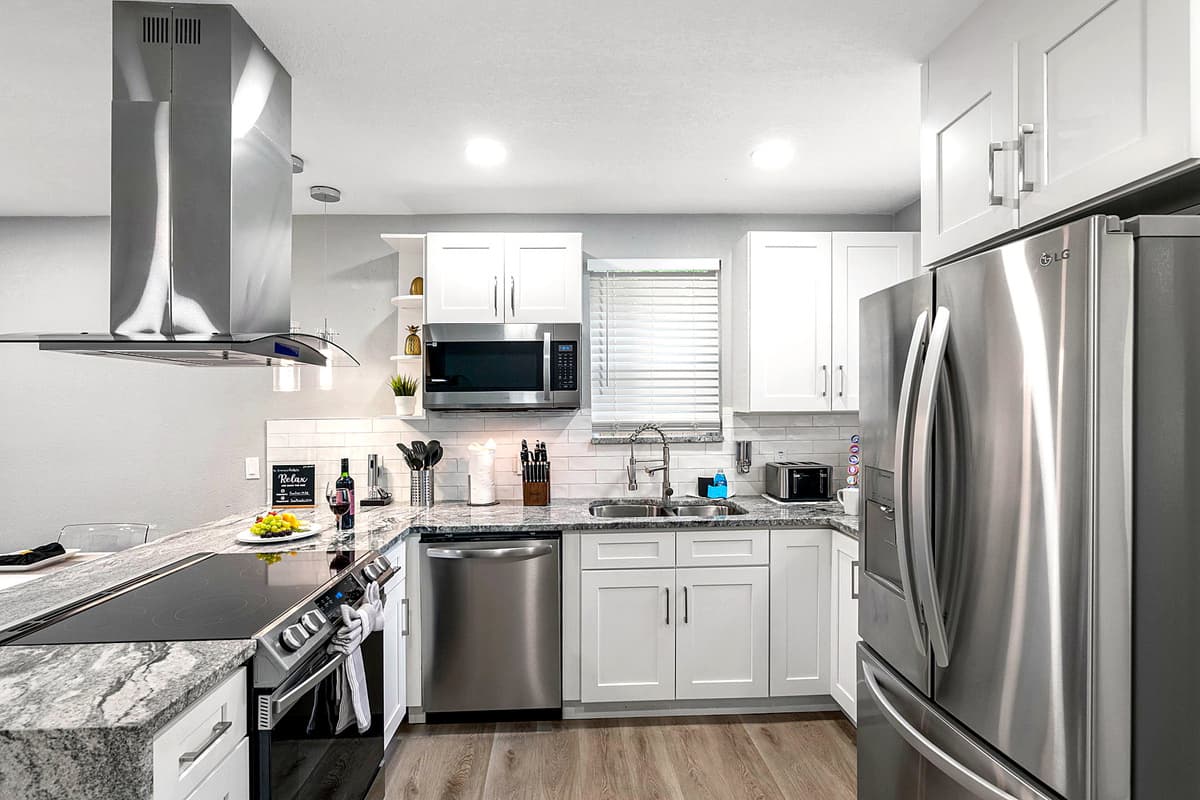 Fully equipped kitchen with stainless steel appliances, granite countertops, and plenty of prep space for cooking meals at home.