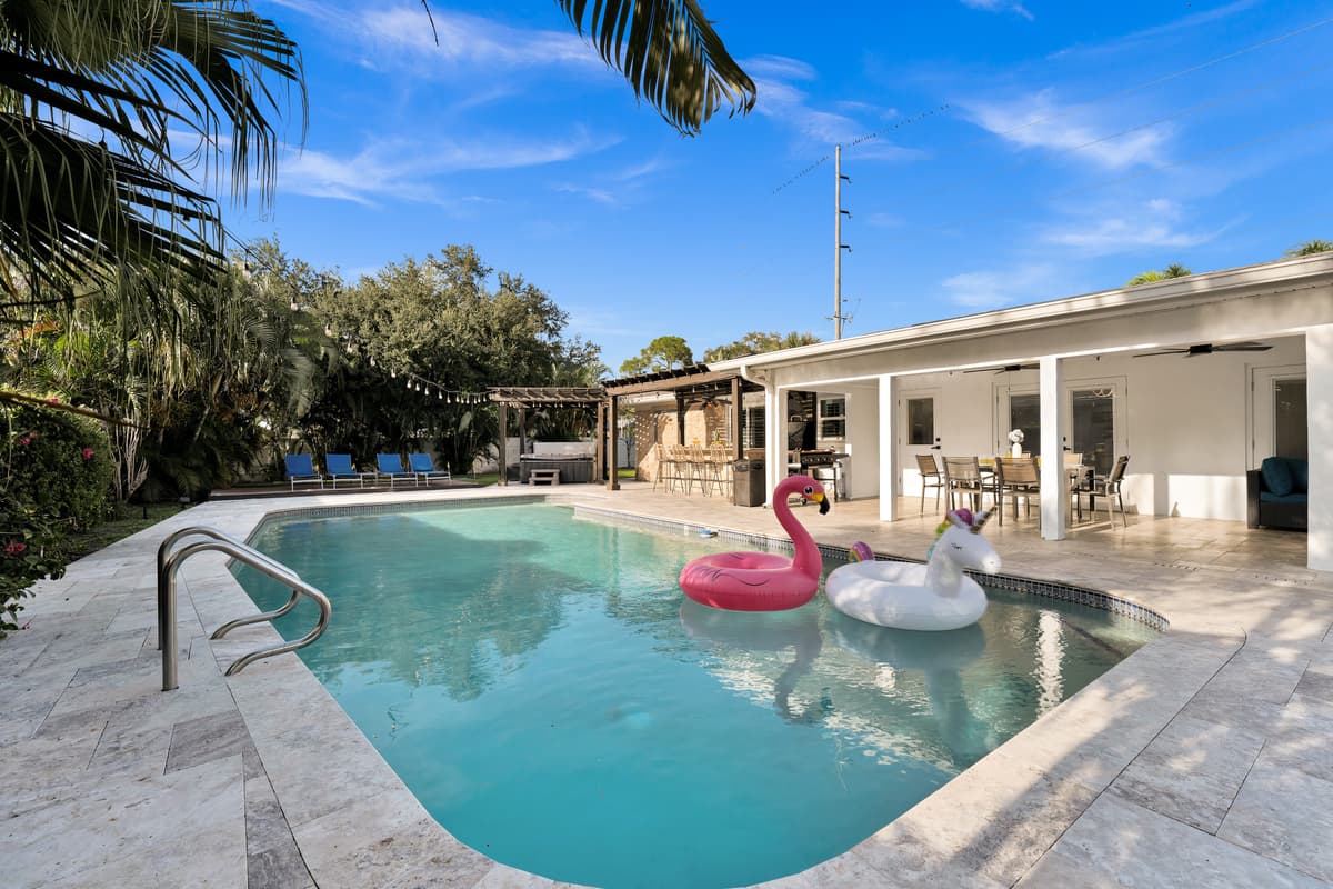 The pool stretches toward the covered lanai, showing off just how much of the home opens onto outdoor living