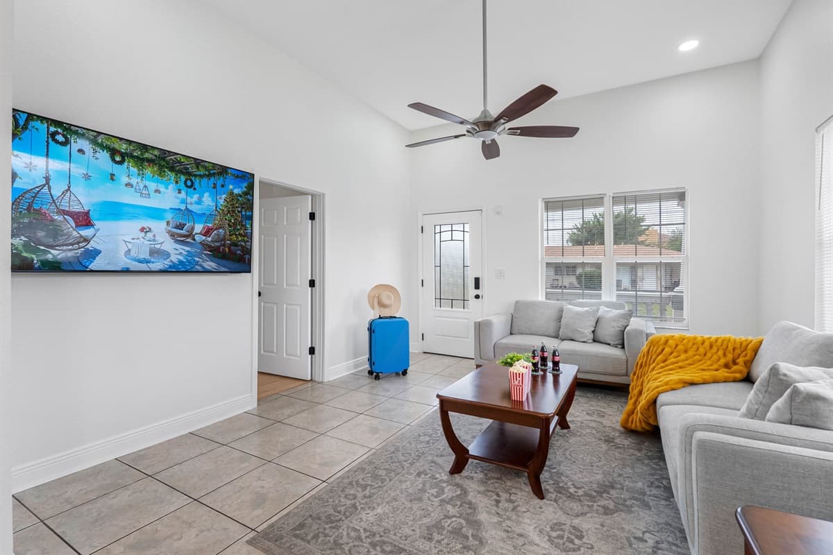 Enjoy this modern living room with plush seating, a flat-screen TV, and plenty of natural light—ideal for movie nights or casual downtime.