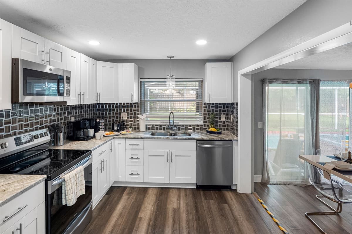 Crisp white cabinetry and warm wood-look flooring combine to create a fresh, inviting space that balances both style and practicality.