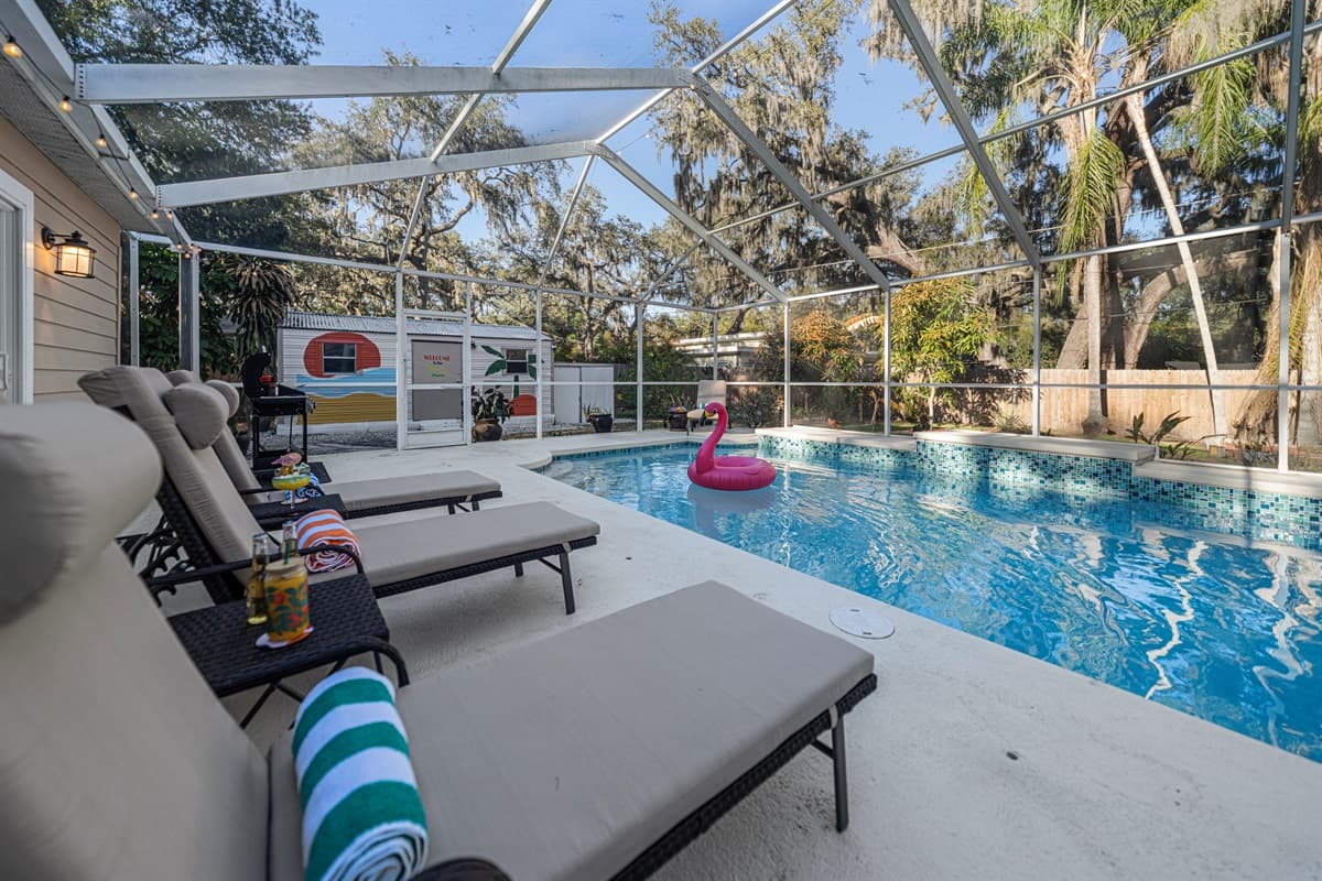 Stretch out and unwind in the spacious screened-in pool area, complete with cozy loungers.
