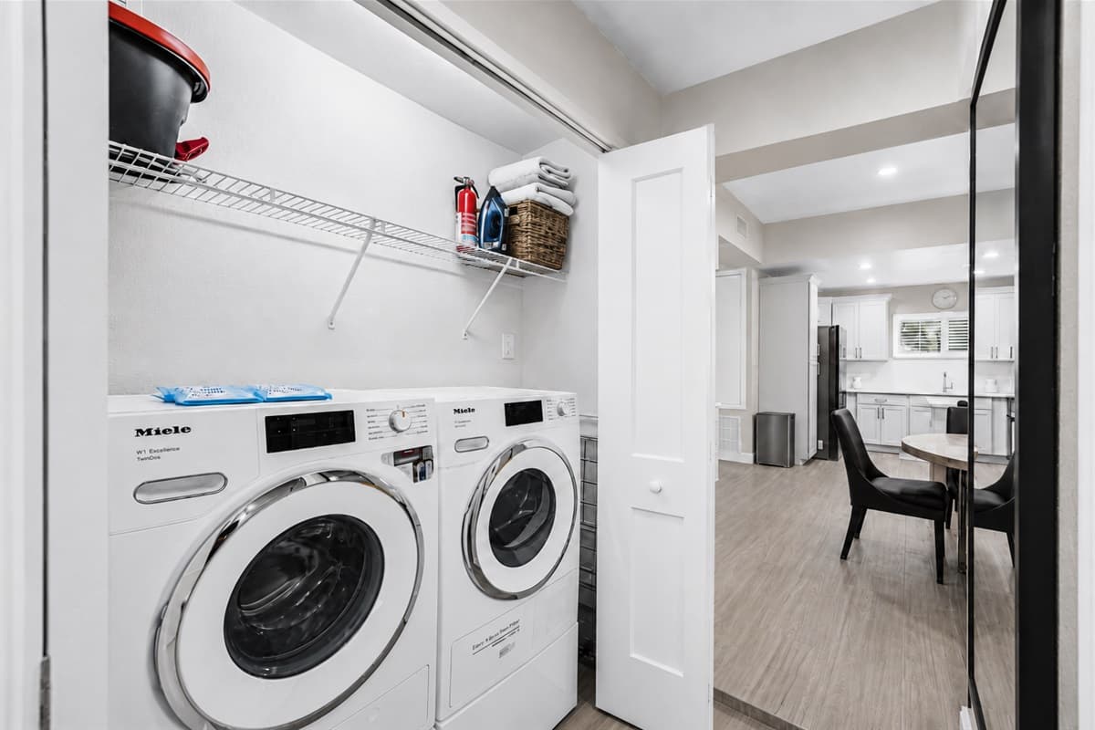 Dedicated laundry area featuring high-end washer and dryer units for added guest convenience.