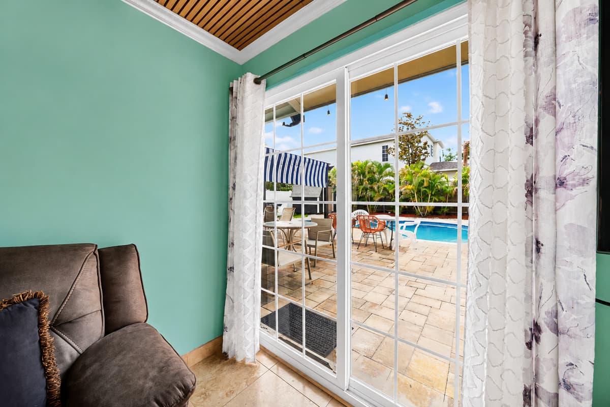 Sliding glass doors provide direct access to the patio and pool area while bringing natural light indoors.
