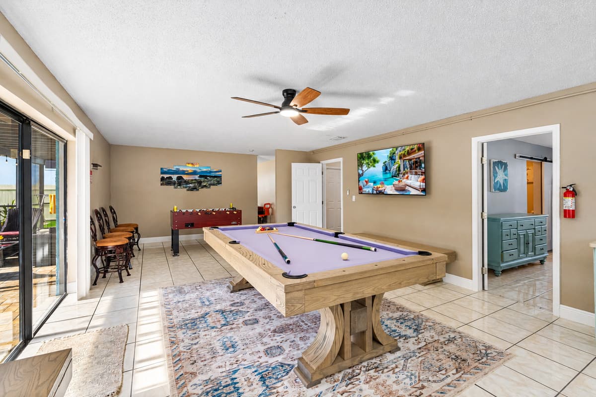 The room is thoughtfully designed with soft neutral tones, tile flooring for easy cleanup, and a ceiling fan to keep you cool while the action heats up.