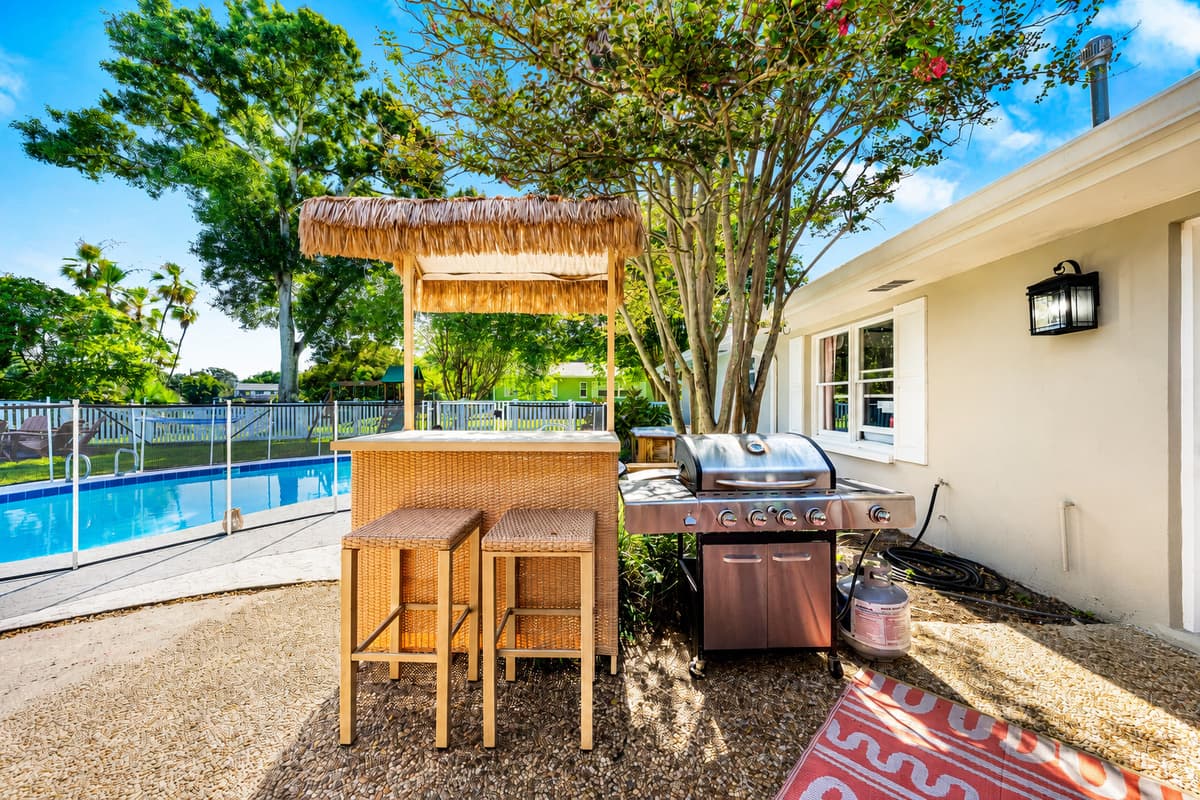 A thatched tiki bar with real stools, right beside the pool. Drinks get poured where people already are.