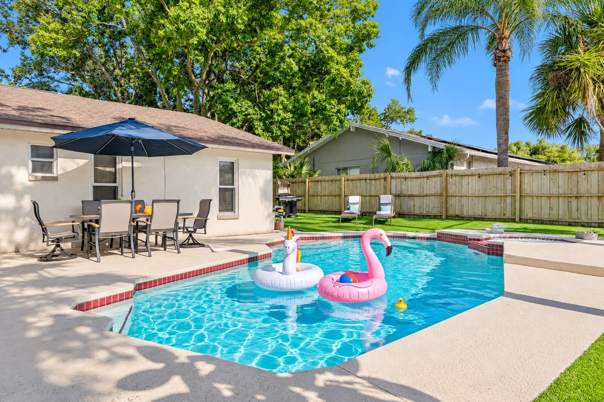 Pool and jetted spa, indoor and outdoor living, putting green, and a comfortable bedroom. The spa has jets and is designed for relaxation; it is not a traditional hot tub. — photo 56