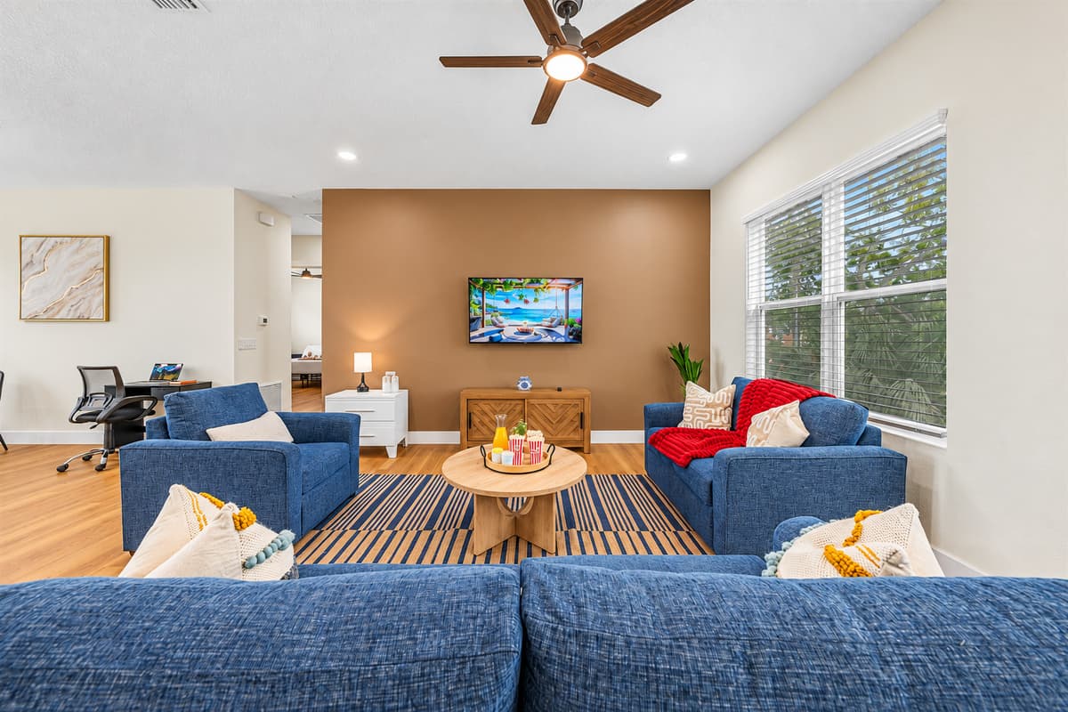 Bright and inviting living room with large windows, cozy seating, and open layout for relaxing.