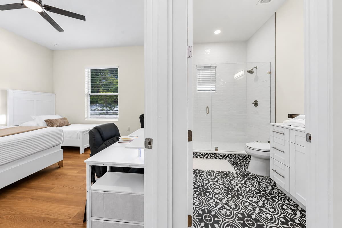 Bathroom 3: glass walk-in shower, vanity, and direct hall access.